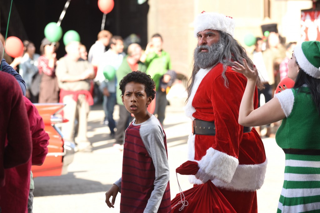 Le petit Sam (Cristian Fagins) est à côté du suspect déguisé en Père Noël
